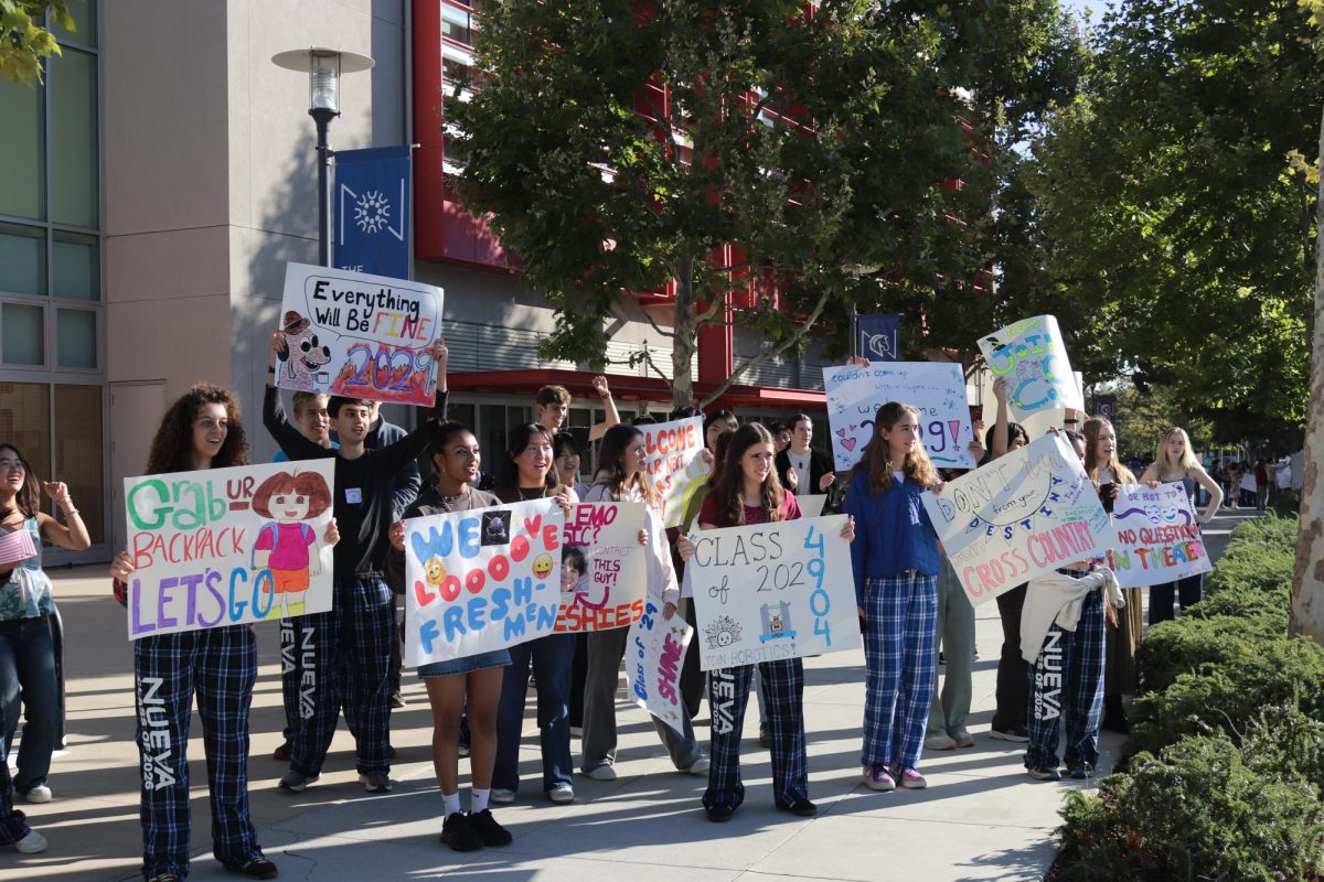 Seniors greet students at the entrance to campus