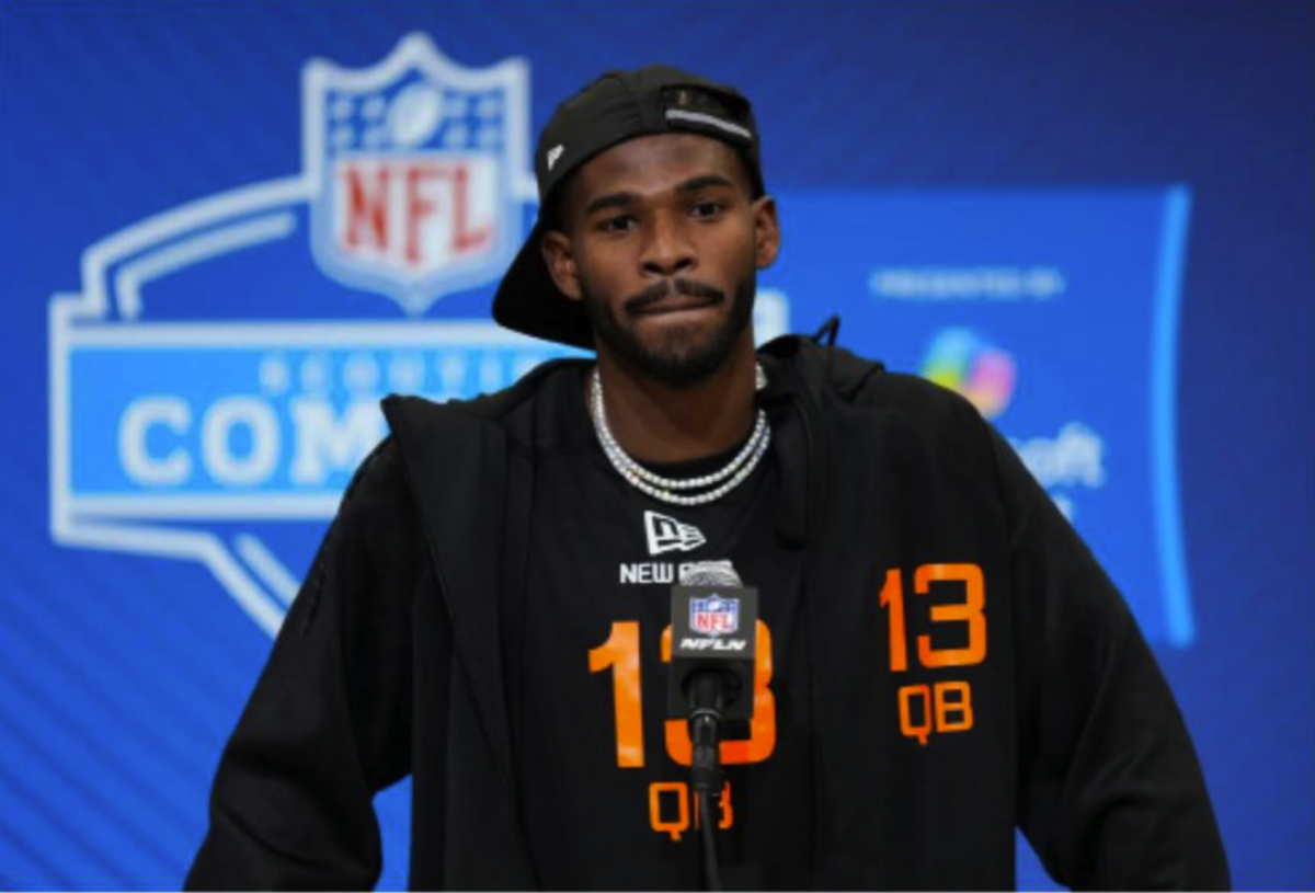 Quarterback Shedeur Sanders stands at the podium in front of reporters and answers their questions