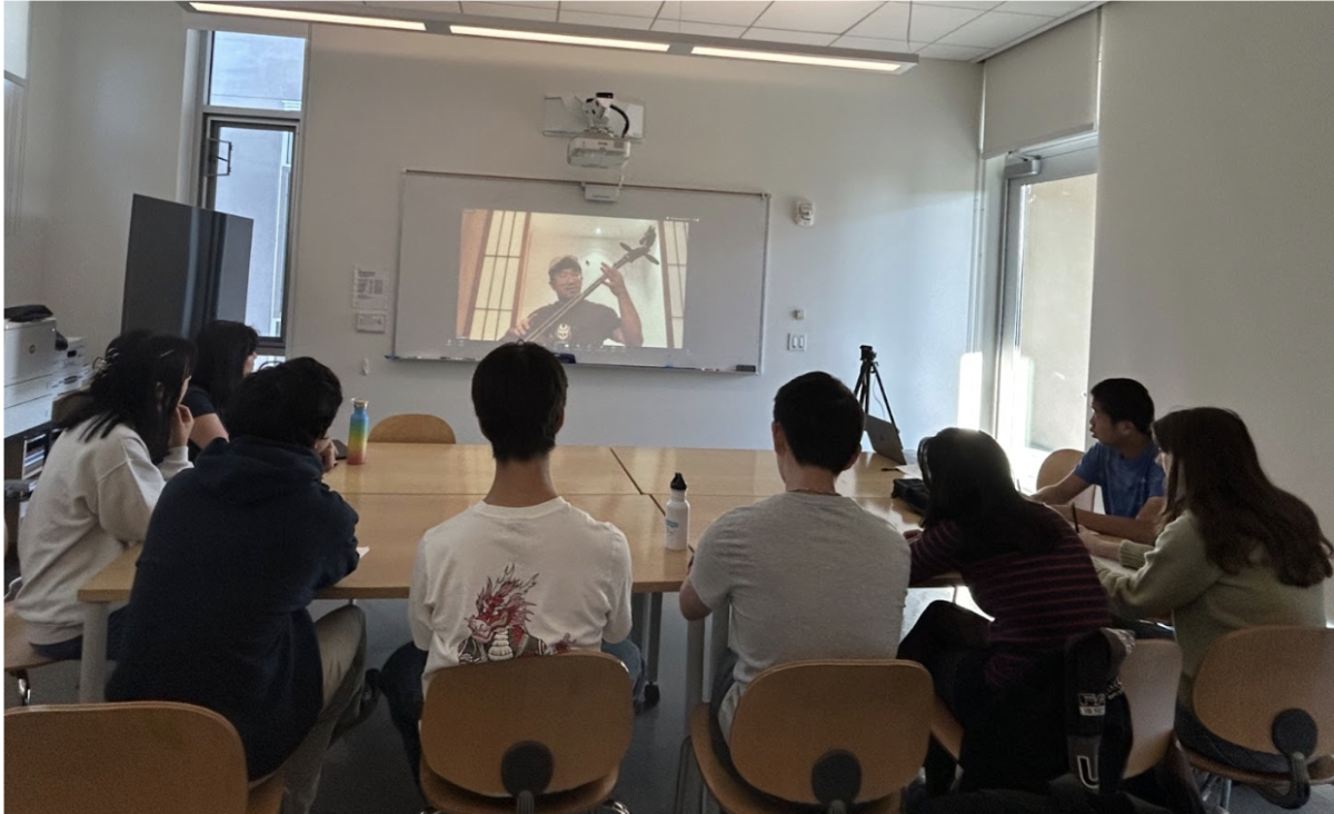 Chinese 5 Communications students watch Ah Tong demonstrate how to play the Morin Khurr. Photo by Ting Zhang.