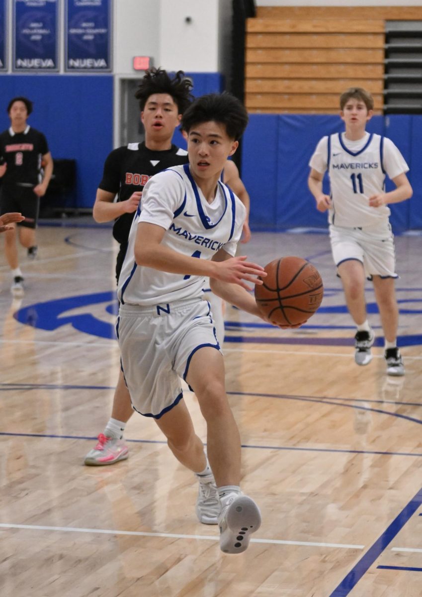 He's a freshman! Star point guard Nigel L. '28 looks to pass down court. // Photo by Diane Mazzoni